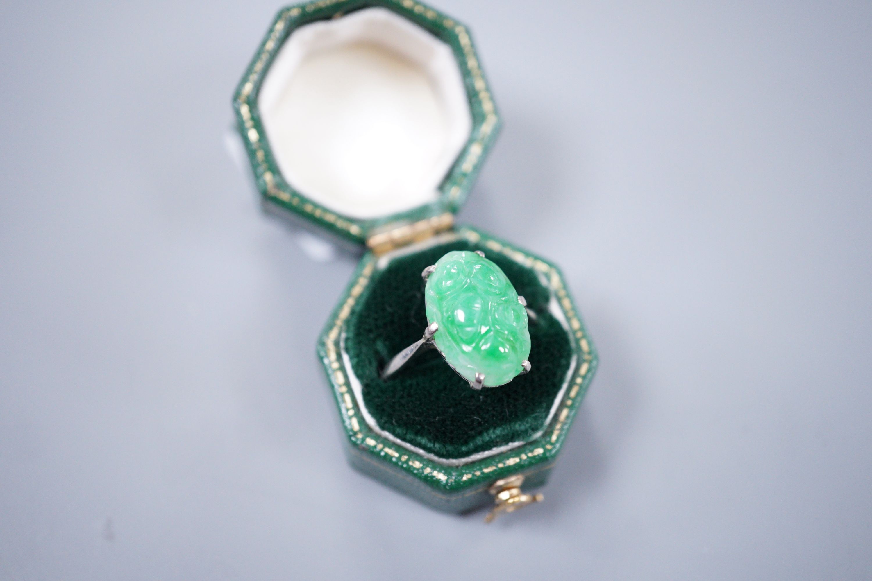 An 18ct white gold and carved jade dress ring, size M, gross 3.9 grams